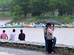 Visitors enjoying the rain at Sukhna Lake in Chandigarh on Friday. (Ravi Kumar/ HT)