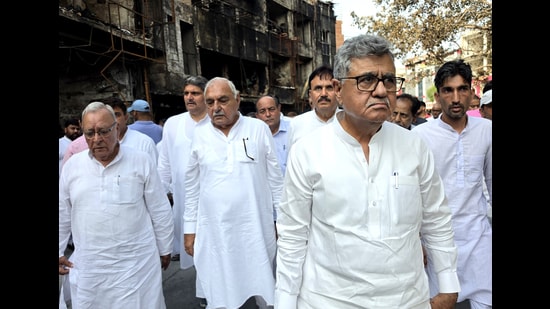 Former Haryana CM and LoP Bhupinder Singh Hooda visits fire-affected shops at D-Park Market in Rohtak on Friday. (Manoj Dhaka/HT)
