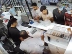 A CCTV grab of the two masked assailants before one of them pulled out a gun to shoot at the cashier, Janki Das (in white shirt), at Sree Kumar Medicos in the busy Sector 11 market in Chandigarh on Saturday afternoon.