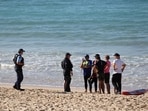 Police gather information from people near Coogee Beach following the shark attack in Sydney.
