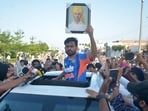 Cockroach Janta Party founder Abhijeet Dipke holds a Shaheed Bhagat Singh photograph during the protest at Golden Gate in Amritsar on Saturday. (Sameer Sehgal/HT)