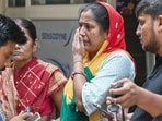 Grieving family members gather outside the residential building in Gali No. 1, Tughlakabad Extension, in New Delhi.