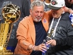 SAN ANTONIO, TEXAS - JUNE 13: New York Knicks owner James Dolan and president Leon Rose celebrate behind the Larry O'Brien Championship Trophy after their team defeated the San Antonio Spurs in Game Five of the 2026 NBA Finals at Frost Bank Center on June 13, 2026 in San Antonio, Texas. (Photo by Gregory Shamus / GETTY IMAGES NORTH AMERICA / Getty Images via AFP)