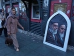 Pedestrians walk past a poster showing the slain Iranian Supreme Leader Ayatollah Ali Khamenei, left, and the late revolutionary founder Ayatollah Khomeini in Tehran, Iran, Sunday, June 14.