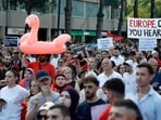 A protestor holds a inflatable flamingo during a demonstration against the construction of a luxury resort near a protected natural area, as they gather in front of Albania's Prime Minister's Office in Tirana on June 15, 2026. (Photo by Adnan Beci / AFP)