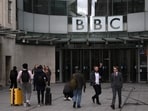People use the front entrance of the headquarters of the British Broadcasting Corporation (BBC) in London.