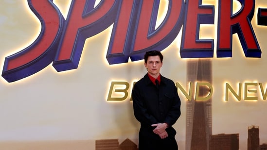 Tom Holland complemented his co-star's vintage-inspired look in a dapper black suit featuring wide-leg trousers and a cropped jacket layered over a vibrant red shirt and matching black tie. The red shirt added a pop of colour to the monochrome look.(AFP)