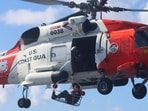 A member of a Coast Guard cyber control team descends onto a dark-fleet vessel