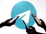 FILE PHOTO: Teenagers pose for a photo while holding smartphones in front of a Telegram logo in this illustration taken September 11, 2025. REUTERS/Dado Ruvic/Illustration/File Photo