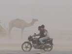 People move amid a dust storm in Prayagraj on Wednesday (PTI)