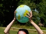 A climate activist poses with an inflatable globe in Geneva.