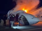 People attempt to pull passengers out of a plane after it crashed on a highway Tuesday, June 16, 2026, in Laredo, Texas.