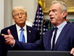 Robert F. Kennedy Jr. delivers remarks while U.S. President Donald Trump listens during a press conference.