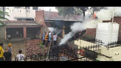 Residents and fire officials douse the blaze in Sundar Nagar, Ludhiana, on Friday. (HT Photo)