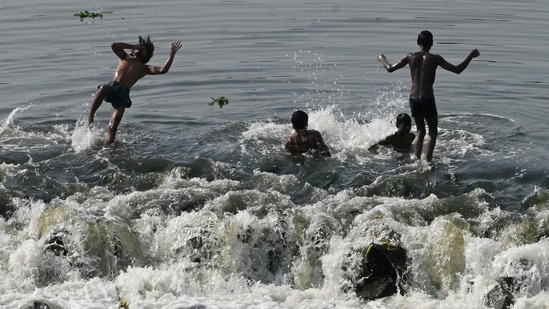 Boys bathe in the Gomti to beat the heat near Kudia Ghat in Lucknow. (HT File Photo)