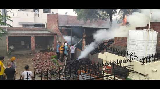 Residents and fire officials douse the blaze in Sundar Nagar, Ludhiana, on Friday. (HT Photo)