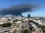 Black smoke rises from a warehouse fire in Boyle Heights as seen from downtown Los Angeles on June 17, 2026. 