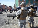 People walk near military personnel standing on guard as they are deployed, after Bolivian President Rodrigo Paz declared a nationwide state of emergency following weeks of violence and blockades, in El Alto, Bolivia