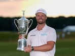 Wyndham Clark holds the trophy after winning the U.S. Open golf tournament at Shinnecock Hills Golf Club in Southampton, N.Y., Sunday, June 21, 2026. (AP Photo/Gerald Herbert)