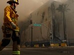 LOS ANGELES, CALIFORNIA - JUNE 20: A firefighter walks down the street as a massive warehouse fire at a cold storage facility continues to burn and spread smoke around the city on June 20, 2026 in Los Angeles, California. (Photo by MARIO TAMA / GETTY IMAGES NORTH AMERICA / Getty Images via AFP)