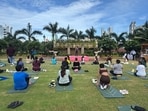 Participants practise yoga at the open-air terrace setting to mark International Day of Yoga