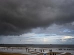 People enjoy a light drizzle on Juhu Beach in Mumbai. (Satish Bate/ HT Photo)