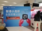 FILE PHOTO: People stand in front of a claw machine filled with lobster-shaped plush toys during a setup session for AutoClaw, a local version of the AI agent OpenClaw developed by Zhipu, at an office building in Beijing, China March 13, 2026. 