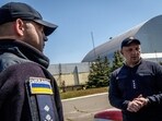 Rescue workers standing outside the Chornobyl Nuclear Power Plant earlier this year.