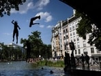 Young people jump from a bridge into the Canal Saint-Martin during a heatwave in Paris.