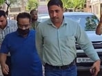 Former principal secretary Pankaj Agarwal (in blue T-shirt) being produced before a Panchkula court on Tuesday. (HT Photo)