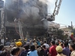 Fire personnel conduct a dousing operation after fire broke out at a commercial building in Aliganj, Lucknow.