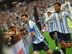Argentina's Lionel Messi celebrates scoring their second goal with Leandro Paredes 
