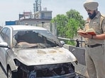 The car that caught fire on Atam Nagar flyover in Ludhiana on Tuesday. (Gurpreet Singh/HT)