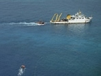 A ship identified by the Philippine Coast Guard as a Chinese research vessel is seen towing a floating structure at Scarborough Shoal in the South China Sea.