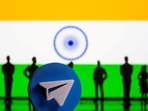 A 3D-printed Telegram app logo and small toy figurines are seen in front of India flag in this illustration 