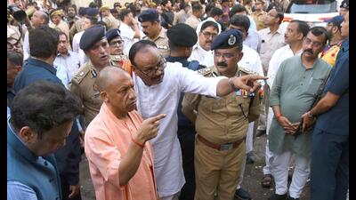 Chief minister Yogi Adityanath along with deputy CM Brajesh Pathak inspected the site of the fire incident at the commercial building housing an animation centre in Lucknow, on Monday. (HT photo)