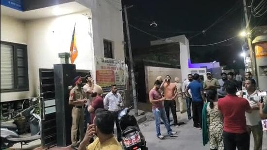 Residents gather outside the clinic of homeopathic practitioners Tarsem Garg and Rajni Jindal, who are recently shifted allegiance from the AAP to the BJP, after the petrol bomb attack in Bathinda on Monday night. (Sanjeev Kumar/HT)