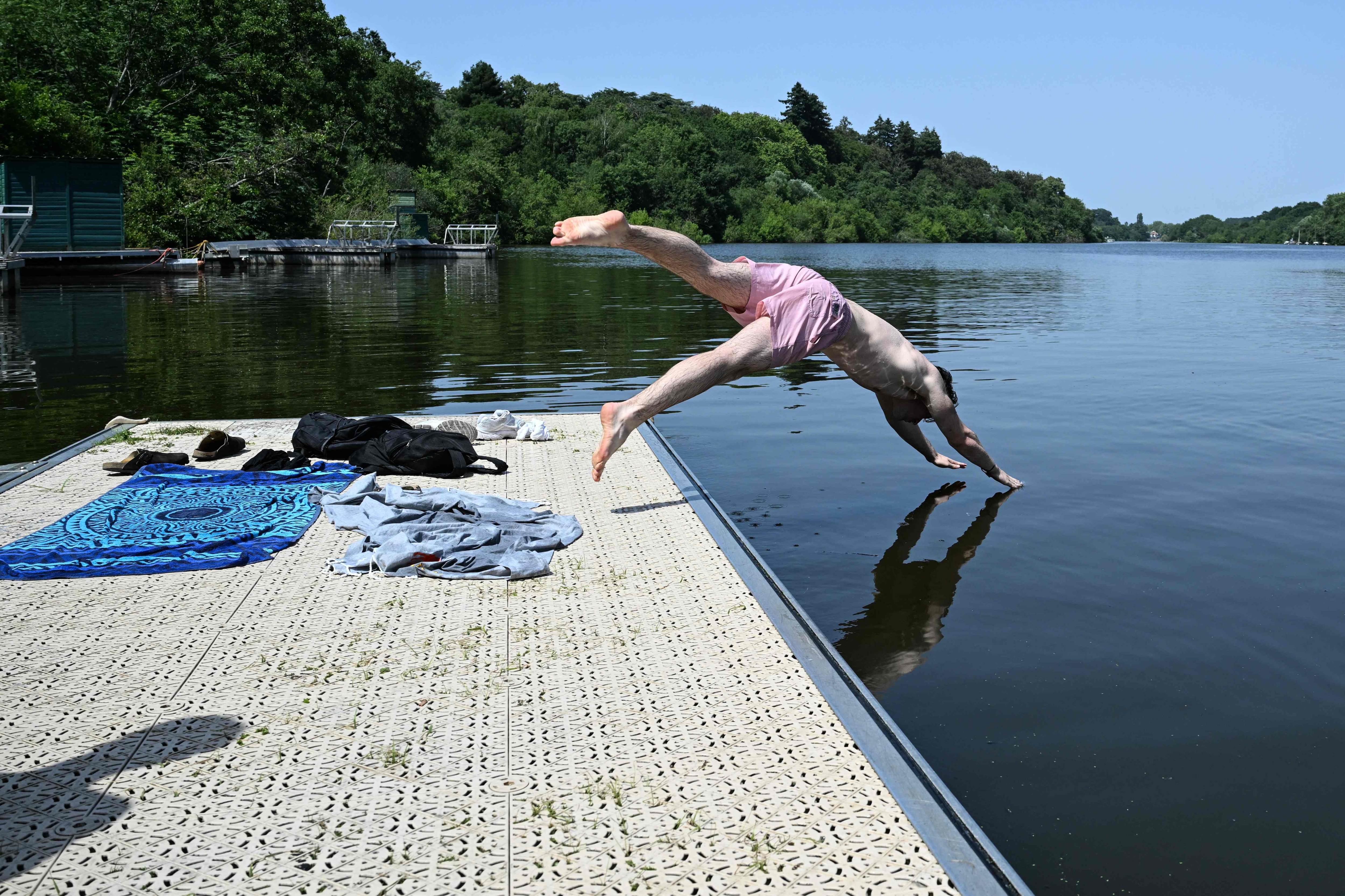 A man dives into the Edre river during a heatwave in Nantes, western France, on June 23, 2026. (Photo by Sebastien Salom-Gomis / AFP) (AFP) A man dives into the Edre river during a heatwave in Nantes, western France, on June 23, 2026. (Photo by Sebastien Salom-Gomis / AFP) (AFP)