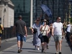 Pedestrians try to keep cool, using fans and umbrellas to shelter form the sun as they walk over Westminster Bridge in London. (AP Photo/Alastair Grant) Pedestrians try to keep cool, using fans and umbrellas to shelter form the sun as they walk over Westminster Bridge in London. (AP Photo/Alastair Grant)