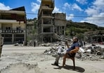 A man sits by rubble in the town of Nabatieh al-Fawqa in southern Lebanon. 
