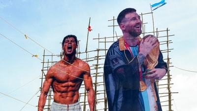 People walk past giant cut-outs of footballers Cristiano Ronaldo and Lionel Messi amid the ongoing FIFA World Cup 2026, in Thiruvananthapuram (PTI) People walk past giant cut-outs of footballers Cristiano Ronaldo and Lionel Messi amid the ongoing FIFA World Cup 2026, in Thiruvananthapuram (PTI)