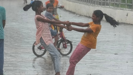 Girls dance in the rain during monsoon shower in Mumbai. (AP)