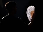 A person uses a hand fan during a heatwave in Brussels, on June 24, 2026. Europe struggled to cope with a record-breaking heatwave on June 24, 2026, with at least 94 million people expected to experience temperatures above 35C, most of them in France and Spain. (Photo by EMILE WINDAL / Belga / AFP) / Belgium OUT(AFP)