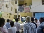 People gather around the home of Girdhari Singh in Sector 5, Vaishali, on Thursday. (Sakib Ali /HT Photo)