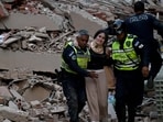 Municipal police officers evacuate an injured victim from a collapsed building following an earthquake in Caracas.