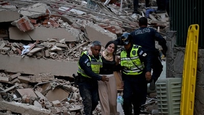 Municipal police officers evacuate an injured victim from a collapsed building following an earthquake in Caracas. (AFP) Municipal police officers evacuate an injured victim from a collapsed building following an earthquake in Caracas. (AFP)