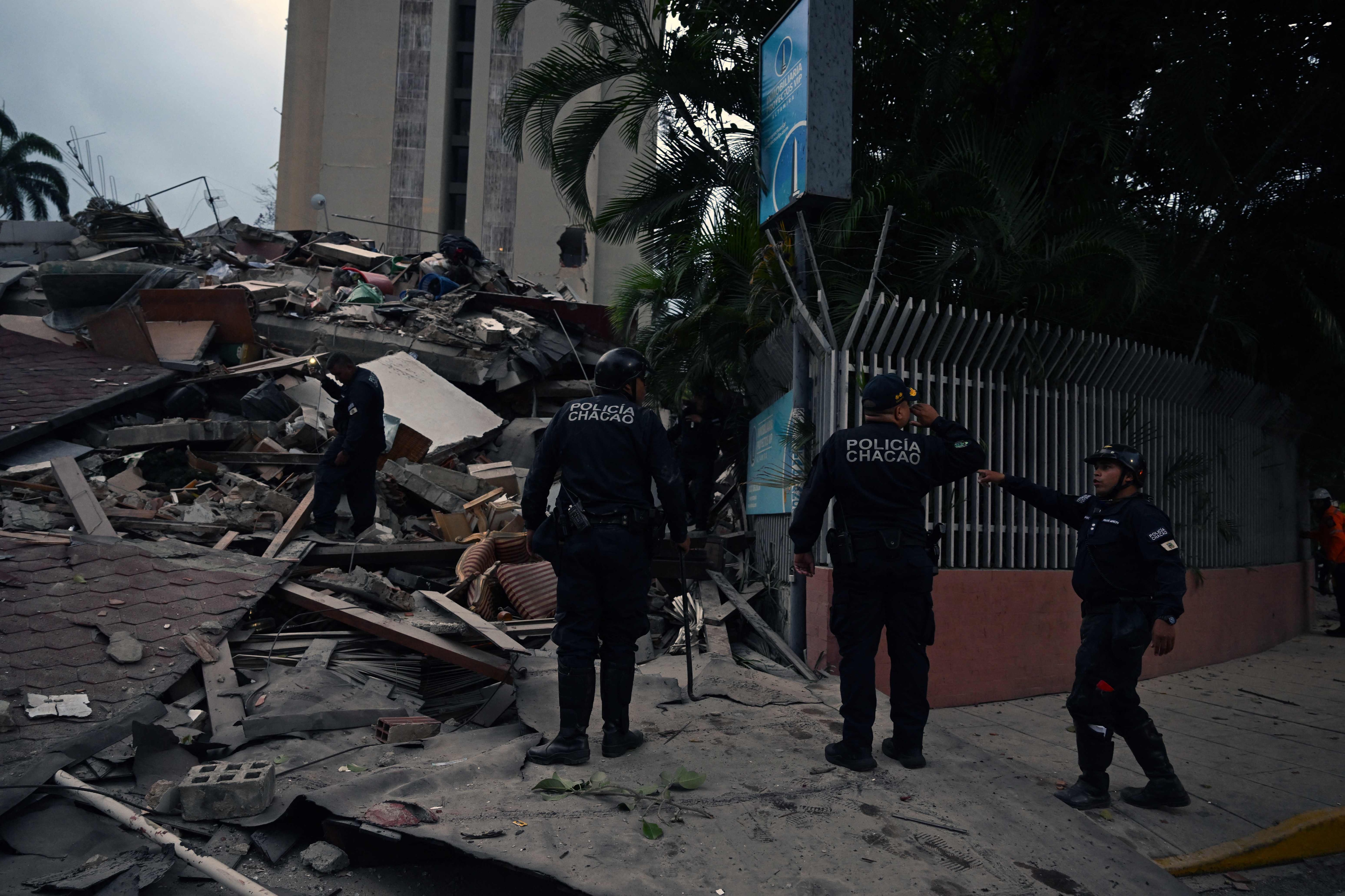 Municipal police officers stand next to the remains of a collapsed structure following an earthquake in Caracas. (AFP) Municipal police officers stand next to the remains of a collapsed structure following an earthquake in Caracas. (AFP)