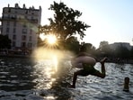 A child jumps into the Canal Saint-Martin after public swimming was permitted in certain areas due to high temperatures amid a heatwave in Paris, France