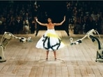 Model Shalom Harlow poses at the Alexander McQueen 1999 Spring/Summer show as robots spray paint onto her dress. (Getty Images)