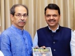 Shiv Sena (UBT) Chief Uddhav Thackeray presents the book 'Why Do You Want Hindi?' compiled by various editors across the state against the compulsory implementation of Hindi, to state Chief Minister Devendra Fadnavis, at Vidhan Bhavan in Mumbai. (@ShivSenaUBT_ X)